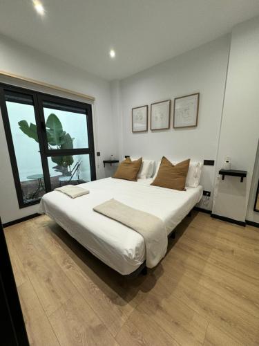 Una cama blanca grande en una habitación con una ventana grande. en Oasis Pavia 15, en Las Palmas de Gran Canaria