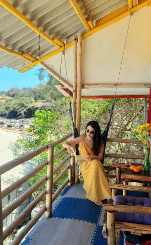 a woman sitting in a hammock on a porch at Long Vĩ hotel - đảo Phú Quý in Cu Lao Thu