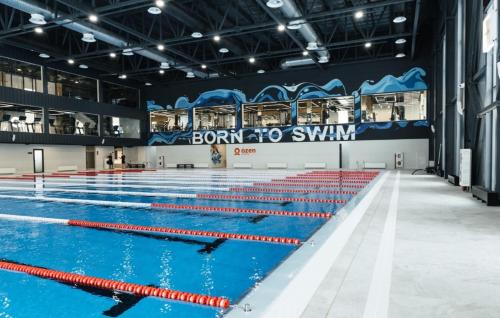 a large swimming pool with blue and red lanes at Respublika LUX Уютная 2-комнатная квартира in Astana
