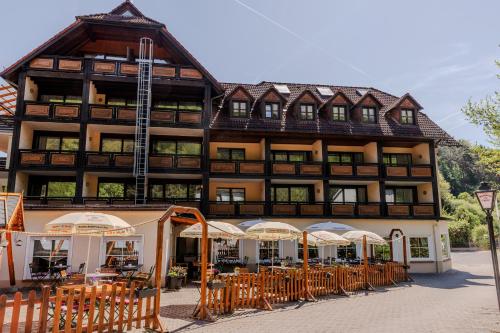 a large building with tables and chairs in front of it at Landgasthof zur Linde in Heimbuchenthal