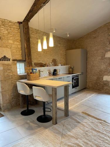 a kitchen with a wooden table and chairs at Figtrees in Margueron