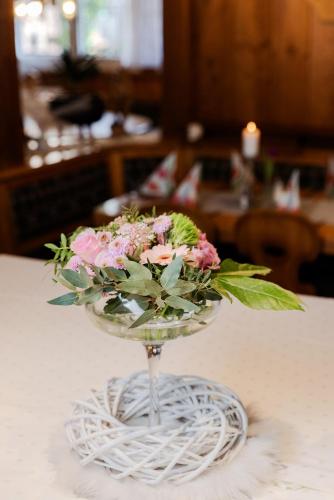 a glass vase filled with flowers on a table at Landgasthof zur Linde in Heimbuchenthal