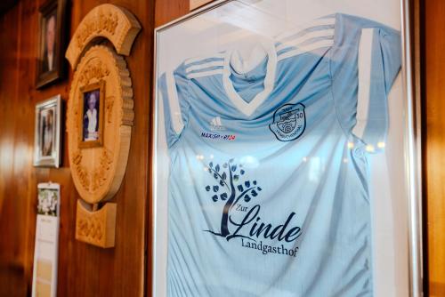 a sign hanging on a wall with a blue dress at Landgasthof zur Linde in Heimbuchenthal