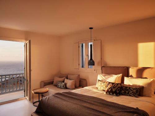 a bedroom with a bed and a view of the ocean at Boho Origin Mykonos in Mýkonos City