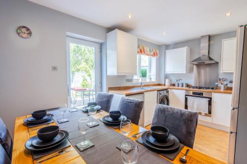 a kitchen and dining room with a wooden table and chairs at Stylish 3BR House - free parking - fast WI-FI- smart tv in Bristol