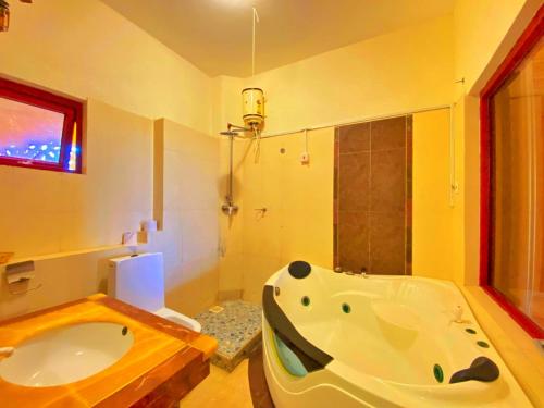 Shanzu Oceanline Apartments and Suites في مومباسا: حمام مع حوض استحمام كبير ومغسلة