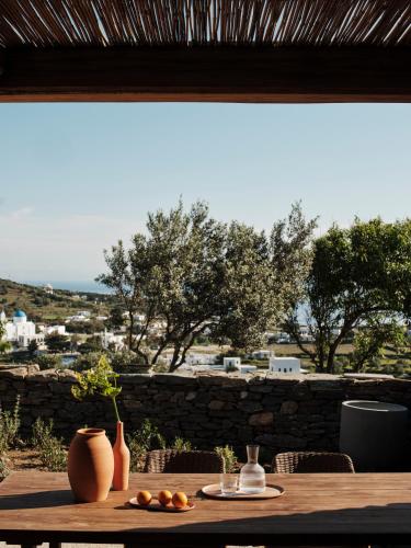a wooden table with a plate of oranges on it at Stamna Sifnos a member of Design Hotels in Sifnos