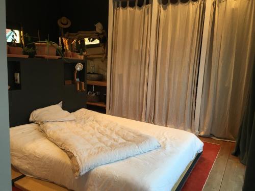 - un lit dans une chambre avec des rideaux dans l'établissement Villa La Pausa, à Capbreton