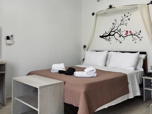 a bedroom with a bed with two towels on it at Orama Milos in Adamas