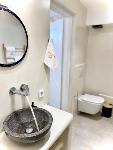 a bathroom with a sink and a mirror at La vie est belle luxury apartment BBQ jacuzzi&view in Pounda