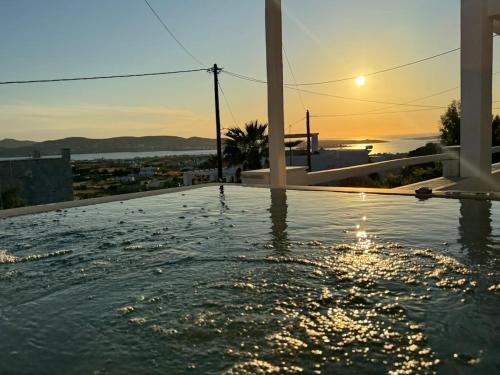 a swimming pool with the sunset in the background at La vie est belle luxury apartment BBQ jacuzzi&view in Pounda