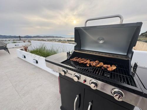 a grill on a patio with food on it at La vie est belle luxury apartment BBQ jacuzzi&view in Pounda