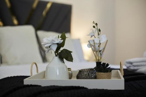 a white vase with flowers in it on a table at Hayy Luxury Retreat At The Lodge in Bradford