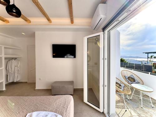 a bedroom with a balcony with a bed and a television at La vie est belle luxury apartment BBQ jacuzzi&view in Pounda