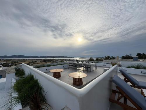 a balcony with tables and tables on a roof at La vie est belle luxury apartment BBQ jacuzzi&view in Pounda