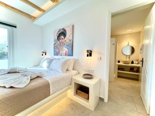 a white bedroom with a bed and a mirror at La vie est belle luxury apartment BBQ jacuzzi&view in Pounda