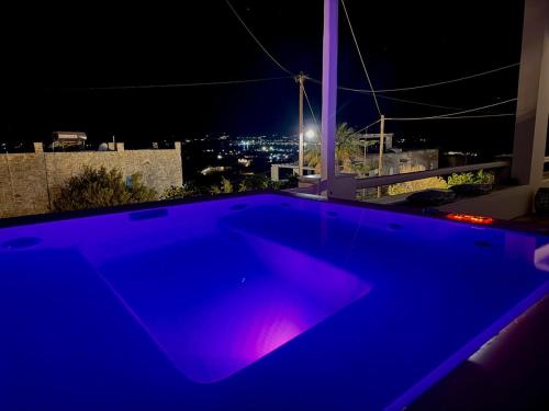 a blue swimming pool with a view at night at La vie est belle luxury apartment BBQ jacuzzi&view in Pounda