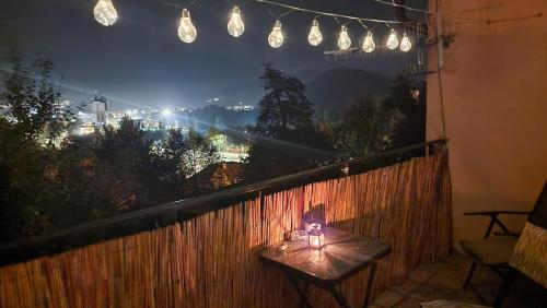 a table on a balcony at night with lights at Big House with beautiful city view, gym,BBQ garden and own parking in Žilina
