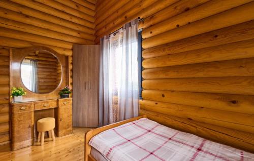 a bedroom with a wooden wall with a bed and a mirror at Holiday Home Zeleni Brijeg by Villas Guide in Petrinja