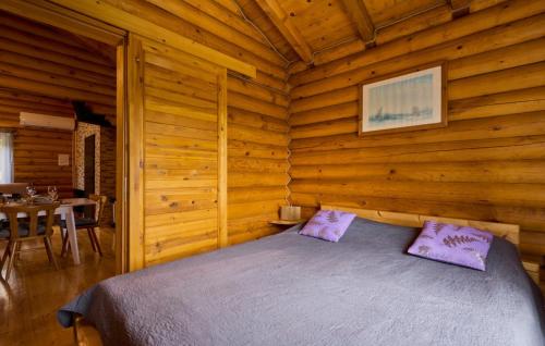 a bedroom with a bed in a log cabin at Holiday Home Zeleni Brijeg by Villas Guide in Petrinja