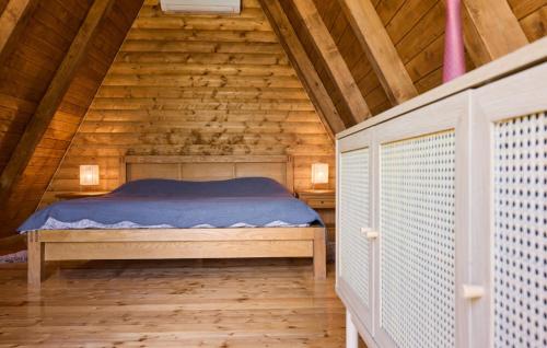 a bedroom with a bed in a wooden cabin at Holiday Home Zeleni Brijeg by Villas Guide in Petrinja