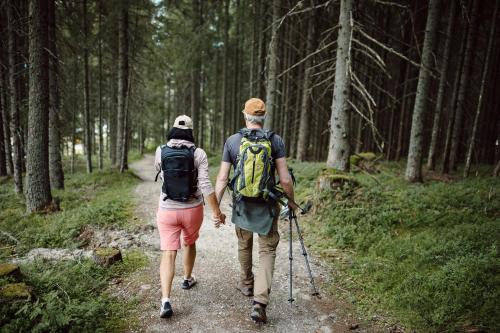 a man and a woman walking down a trail at Hotel Waldfrieden in Schladming