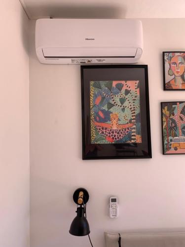 a picture hanging on a white wall with a white at Chambre d hôte avec clim terrasse et petit déjeuner Hauteurs de Nice in Nice