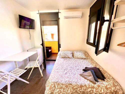 a small bedroom with a bed and a desk at MT Boutique Suites y Apartamentos - Adults Only - in Mataró