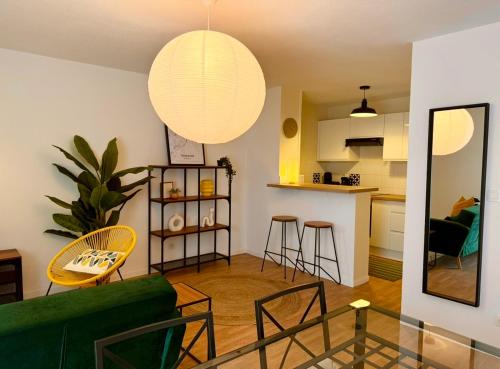 un salon avec un canapé vert et une table dans l'établissement 45m2 cosy & lumineux - Parking gratuit - Accès centre ville rapide - Check-in autonome, à Toulouse