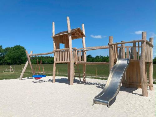 une aire de jeux avec un toboggan et une balançoire dans l'établissement Camping le Ranch - Naujac sur Mer, à Naujac-sur-Mer