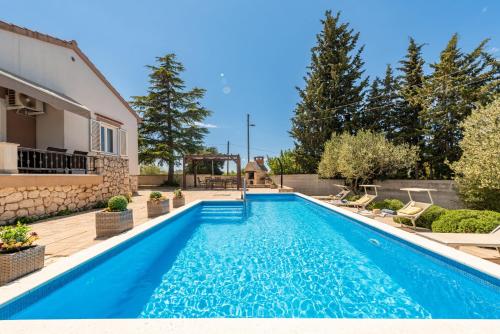 a swimming pool in the backyard of a house at Villa Meštrović ZadarVillas in Zadar