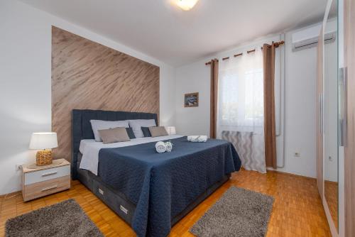 a bedroom with a large bed with a blue blanket at Villa Meštrović ZadarVillas in Zadar