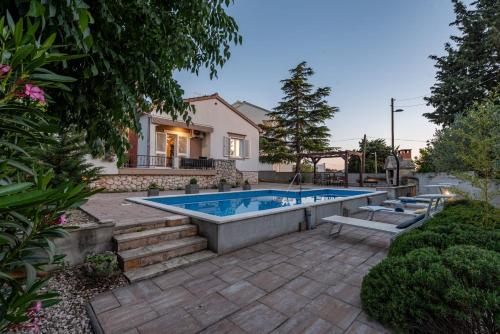 a swimming pool in the backyard of a house at Villa Meštrović ZadarVillas in Zadar