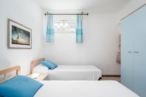 une chambre avec deux lits et une fenêtre dans l'établissement La Vela Arancione, à Orosei