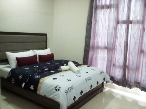a bedroom with a bed with a black and white comforter at Mstaycation in Melaka