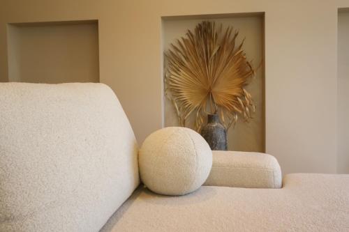 a room with a couch and a vase with a plant at Apartamentai Astra in Druskininkai