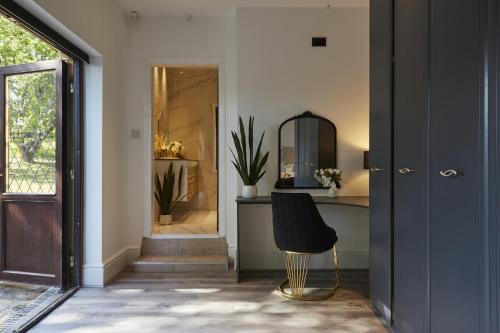 a hallway with a black chair in front of a door at Hayy Luxury Retreat At The Lodge in Bradford