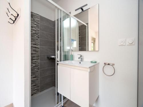 une salle de bain blanche avec un lavabo et une douche dans l'établissement LA DUNE 72 - Villa 3P6, à Valras-Plage