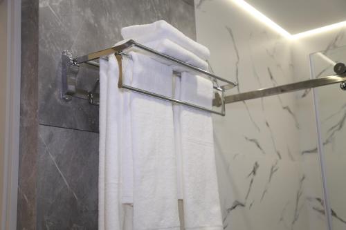 a towel rack with white towels in a bathroom at Tillokori Plaza in Samarkand