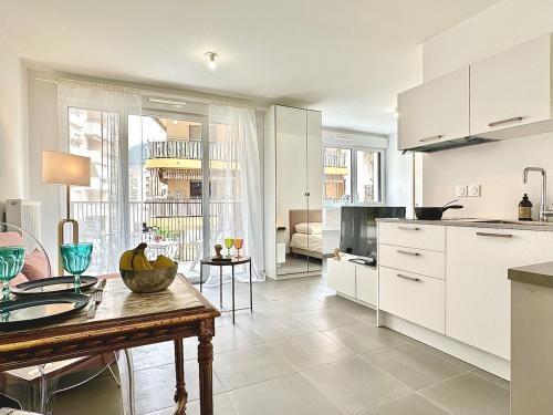 une cuisine avec des armoires blanches et une table dans l'établissement Port Of Nice - with Balcony, à Nice