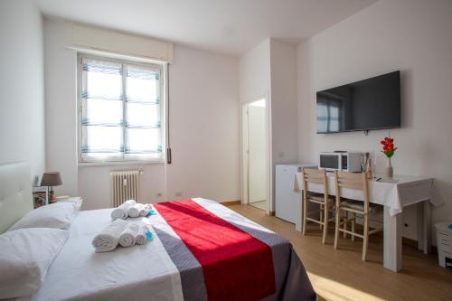 a bedroom with a bed and a desk and a television at Blue's Place - Vicino Stazione Chiasso in Como