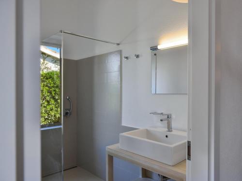 Un baño blanco con lavabo y espejo. en Villa Bua, en Costa Rei