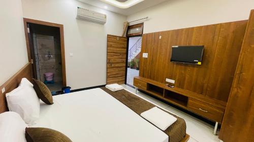 a hotel room with a bed and a flat screen tv at Hotel Pushkar Town in Pushkar