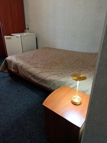 a bedroom with a bed and a wooden table at Kremin Hotel in Kremenchuk