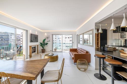 une cuisine et un salon avec une table et des chaises dans l'établissement Modern apartment - 3BR- 6P - Croisette Plage, à Cannes