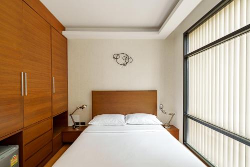 a bedroom with a bed and a large window at Marvin Suites Hotel in Bangkok