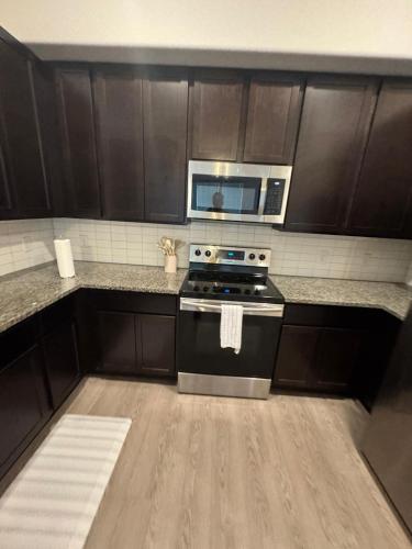 a kitchen with a stove and a microwave at Leander Gem Near Austin in Leander