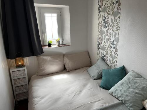 - un canapé blanc dans une chambre avec fenêtre dans l'établissement Au coeur du village avec petit balcon plein sud, à Tourtour