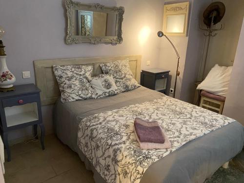 La Maison de Jeanne في Châteney: غرفة نوم مع سرير ومرآة على الحائط