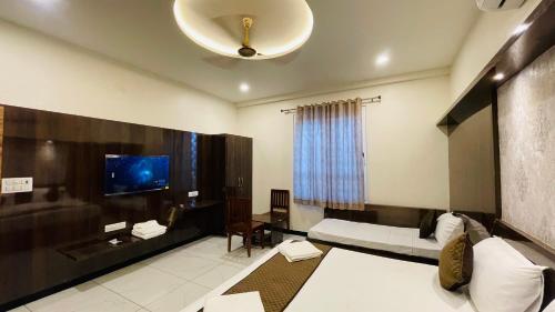 a room with two beds and a tv and a table at Hotel Pushkar Town in Pushkar